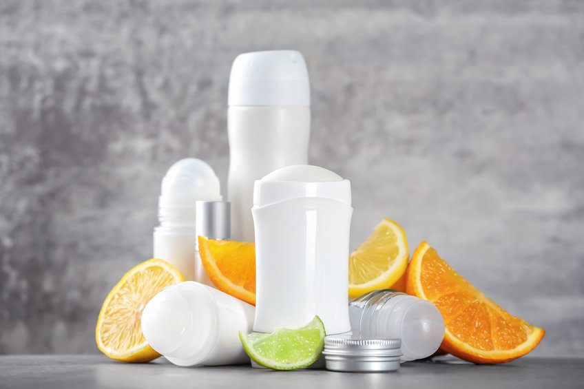 Deodorants for women and citrus fruits on table